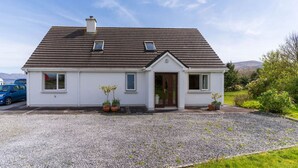 Einbungalow mit Satteldach, einer Haustür und zwei Fenstern.
