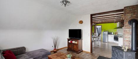 Un salon comprenant un canapé, une table basse, un téléviseur et une cheminée.