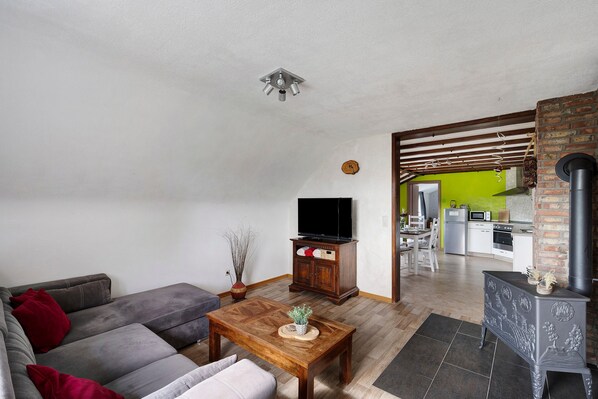 A living room with a sofa, a coffee table, a television, and a fireplace.