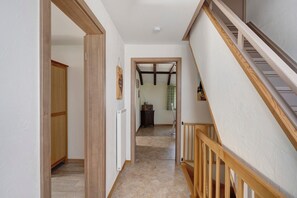 A hallway with a wooden staircase, a radiator, and a door leading to another room. - Apartment 'Ferienwohnung Hohes Venn' with Wi-Fi (Monschau)