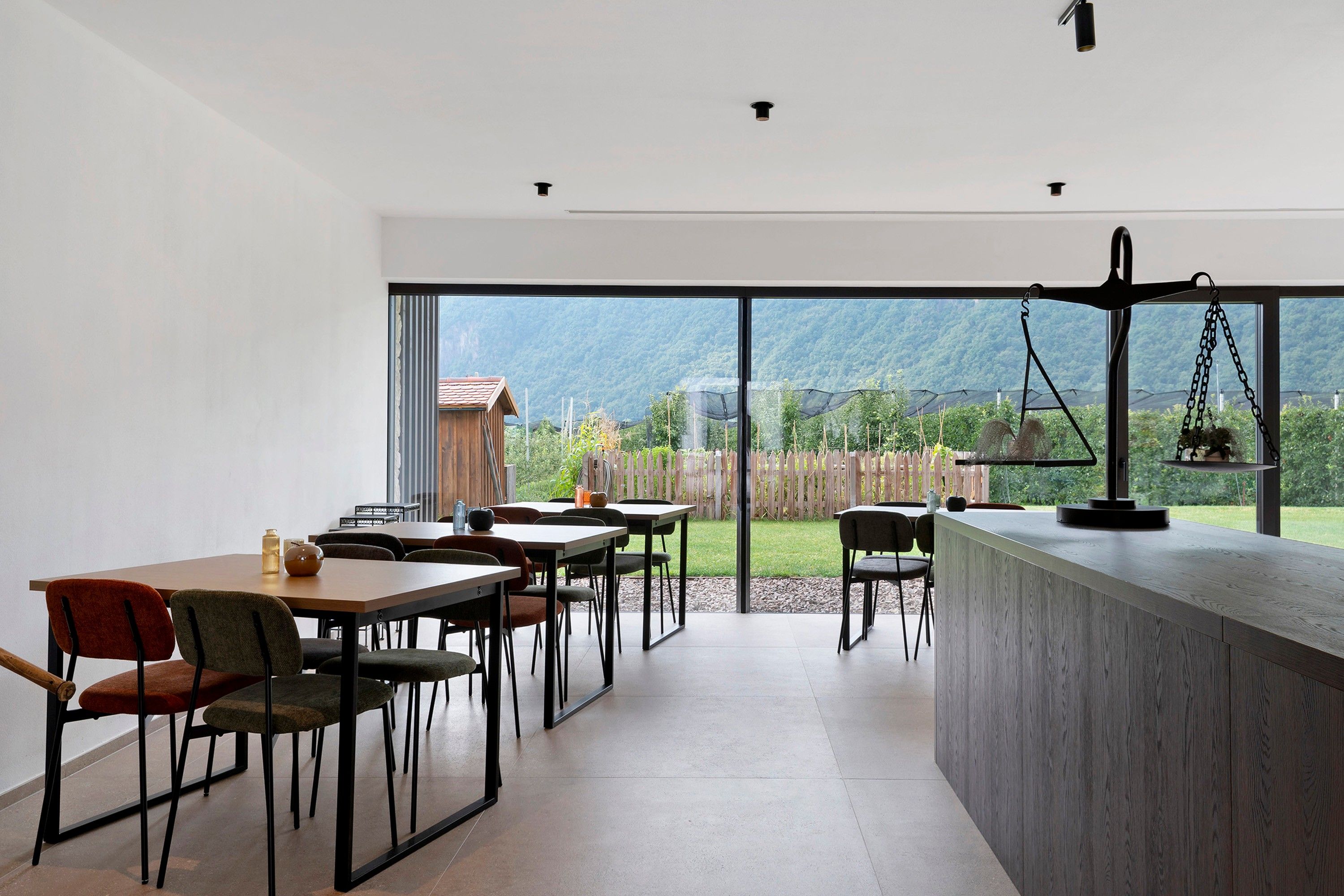 Een modern interieur met een eethoek, een bar en uitzicht op een bergachtig landschap.