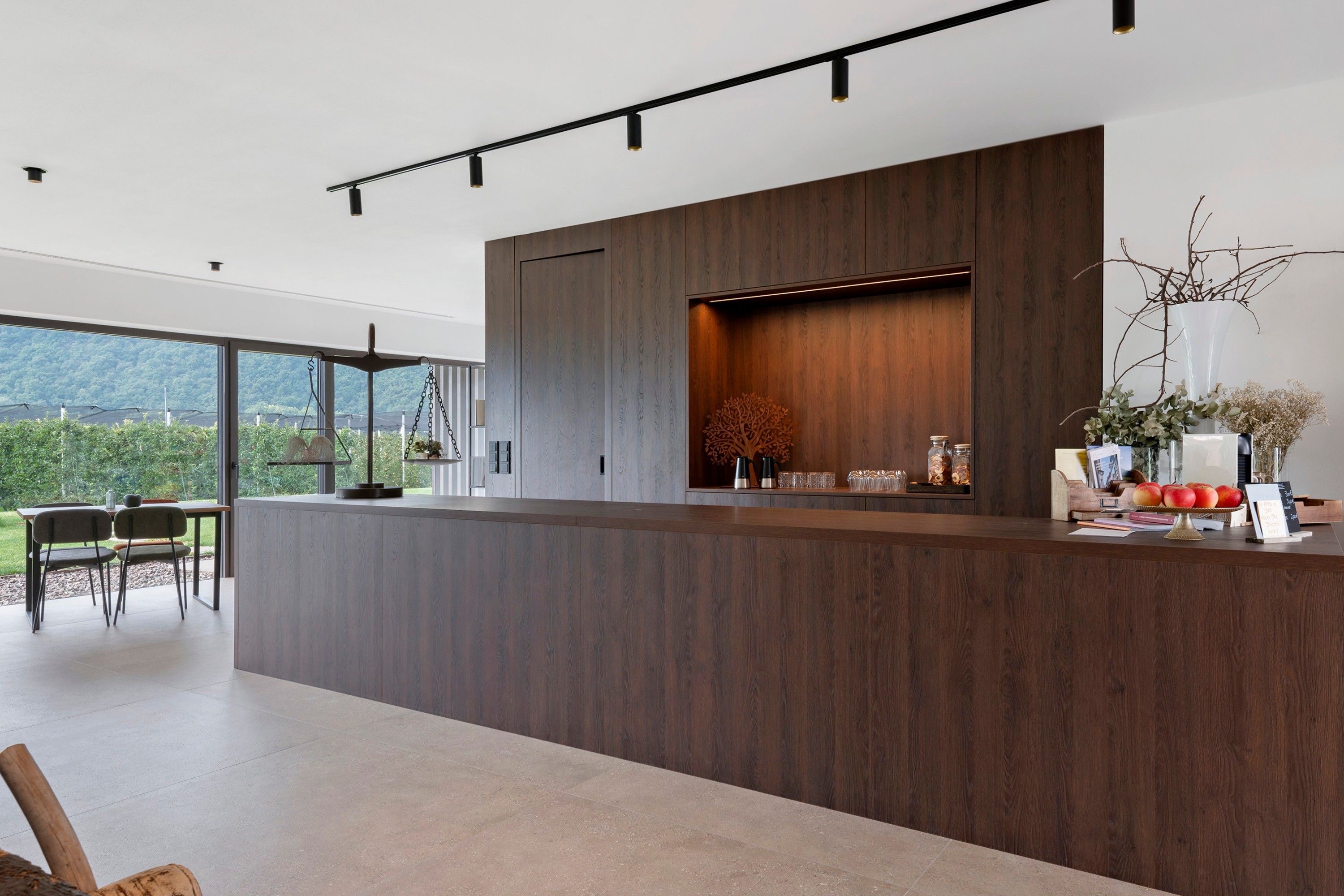 Una cocina moderna con una isla grande, electrodomésticos integrados y vistas al exterior.