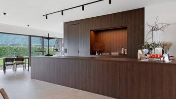 Una cocina moderna con una isla grande, electrodomésticos integrados y vistas al exterior.