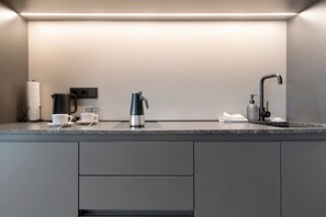 A modern kitchen with a built-in coffee maker, a kettle, and a soap dispenser. - Apartment 'Grafferhof IV' with Mountain View, Wi-Fi, and Air Conditioning (Bolzano)