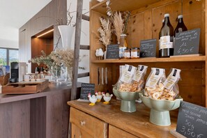 A café counter with various food items and beverages, including jars of marmalade and apple juice, and bags of dried apples. - Apartment 'Grafferhof IV' with Mountain View, Wi-Fi, and Air Conditioning (Bolzano)