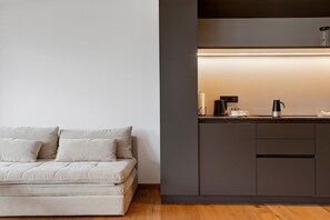Un espace de vie moderne comprenant un canapé et un coin cuisine.
