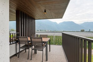 Un balcon avec une table et des chaises, donnant sur un paysage montagneux.