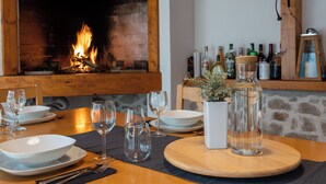 A dining table set with white plates, clear glasses, and cutlery, with a fireplace in the background. - S Villa With Pool, Jacuzzi & Gym (Vodice)
