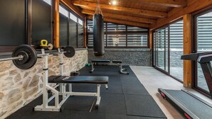 A gym with a weight bench, squat rack, punching bag, and treadmills. - S Villa With Pool, Jacuzzi & Gym (Vodice)