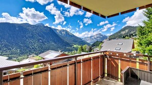 Ein Balkon mit Blick auf Berge und einen klaren Himmel.