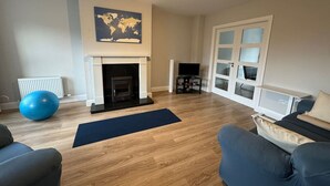 Ein Wohnzimmer mit Kamin, einer großen Weltkugel und einem Fernseher.