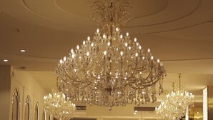 Un hall d’hôtel spacieux, agrémenté d’un grand lustre, de meubles élégants et d’un design moderne.