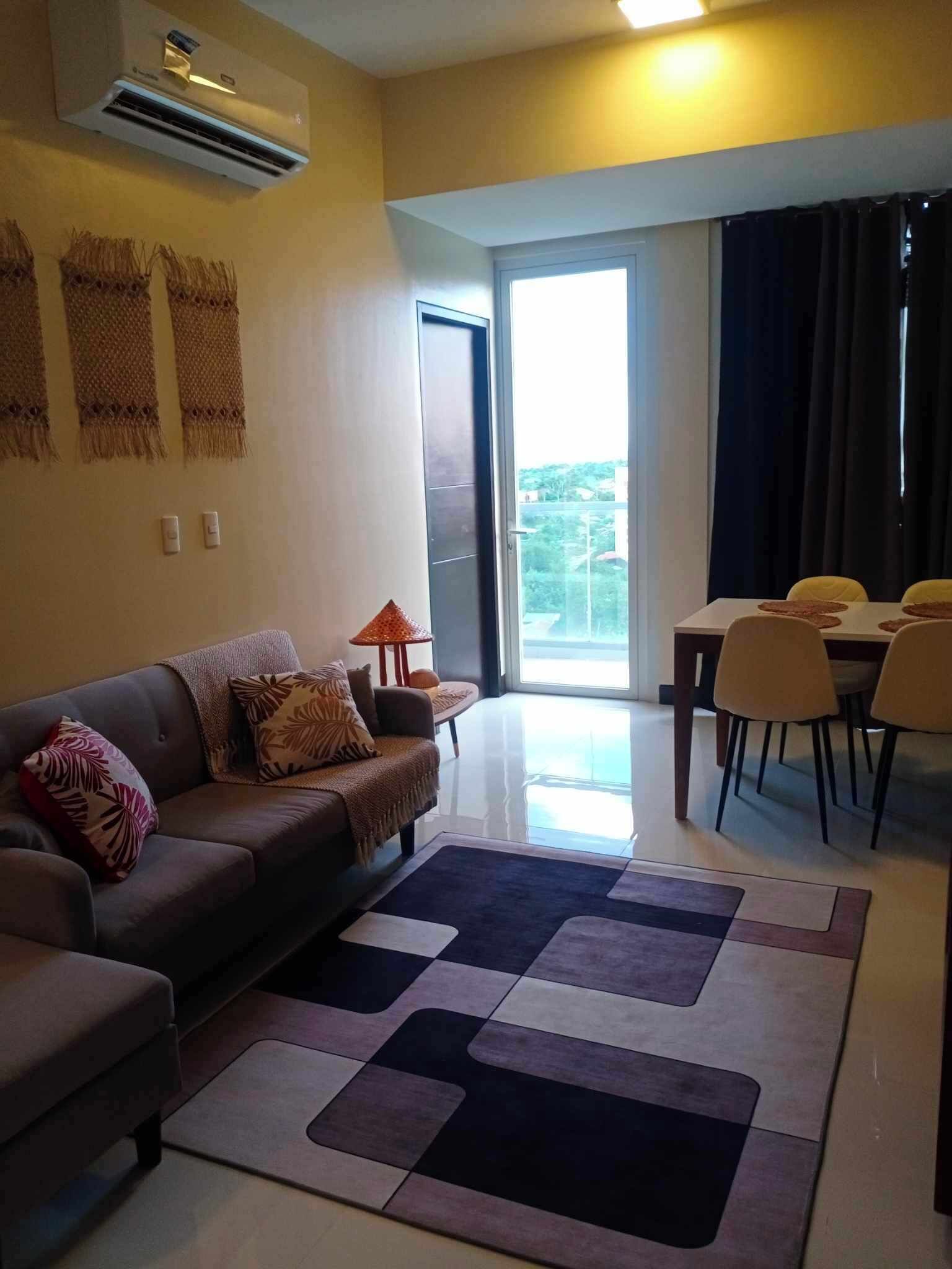 Una sala de estar con sofá, una mesa de centro y un comedor con sillas.
