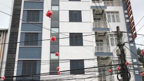 A multi-story building with a sign for 'HOTEL MINH DUC 3' indicating a hotel.