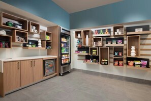 Eine moderne Küchenzeile mit eingebauten Regalen, einem Kühlschrank und einer Kaffeemaschine.
