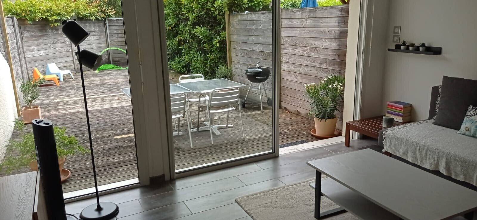 En moderne stue med en skydedør, der fører ud til en udendørs terrasse.