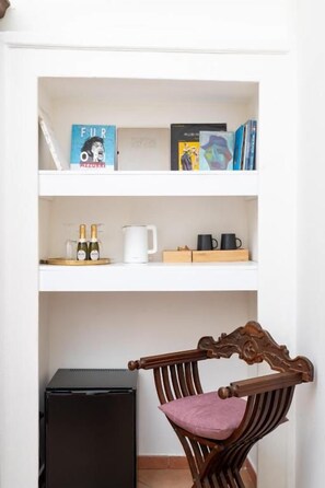 Uma estante com livros e uma garrafa de vinho.