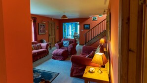 A cozy living room with red sofas, a wooden coffee table, and a staircase leading to another level. - An Charraig - Killarney (Killarney)