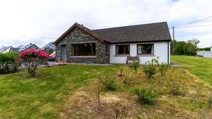 A house with a stone facade, a pitched roof, and a front porch. - Valentia central,  high spec bungalow wifi &views (Reenglass)