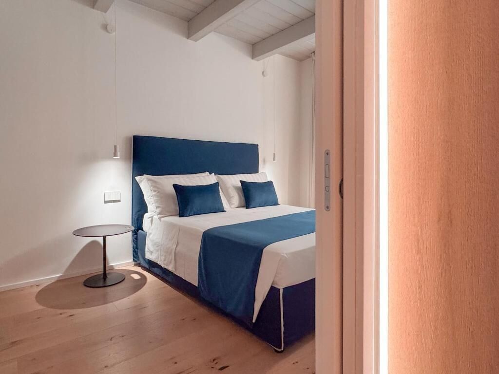 A bedroom with a bed, bedside table, and a door.
