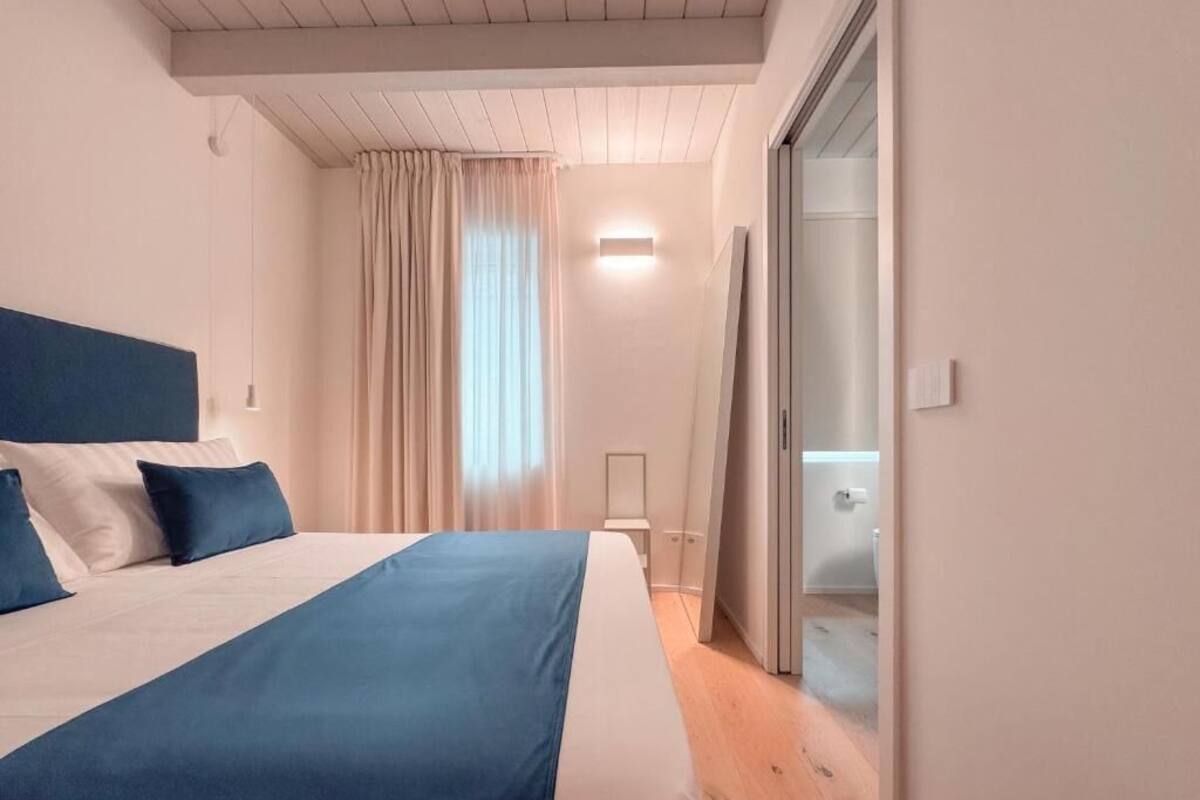 A bedroom with a bed, a sliding door, a bedside table, and a light fixture.