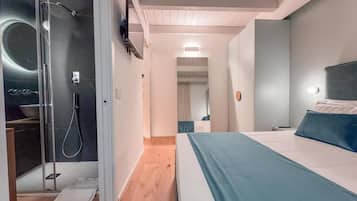 Een moderne slaapkamer met een groot bed, een inloopkast en een douchehoek.