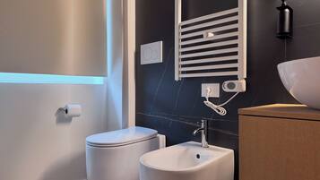Une salle de bain moderne équipée de toilettes, d’un bidet et d’un lavabo.