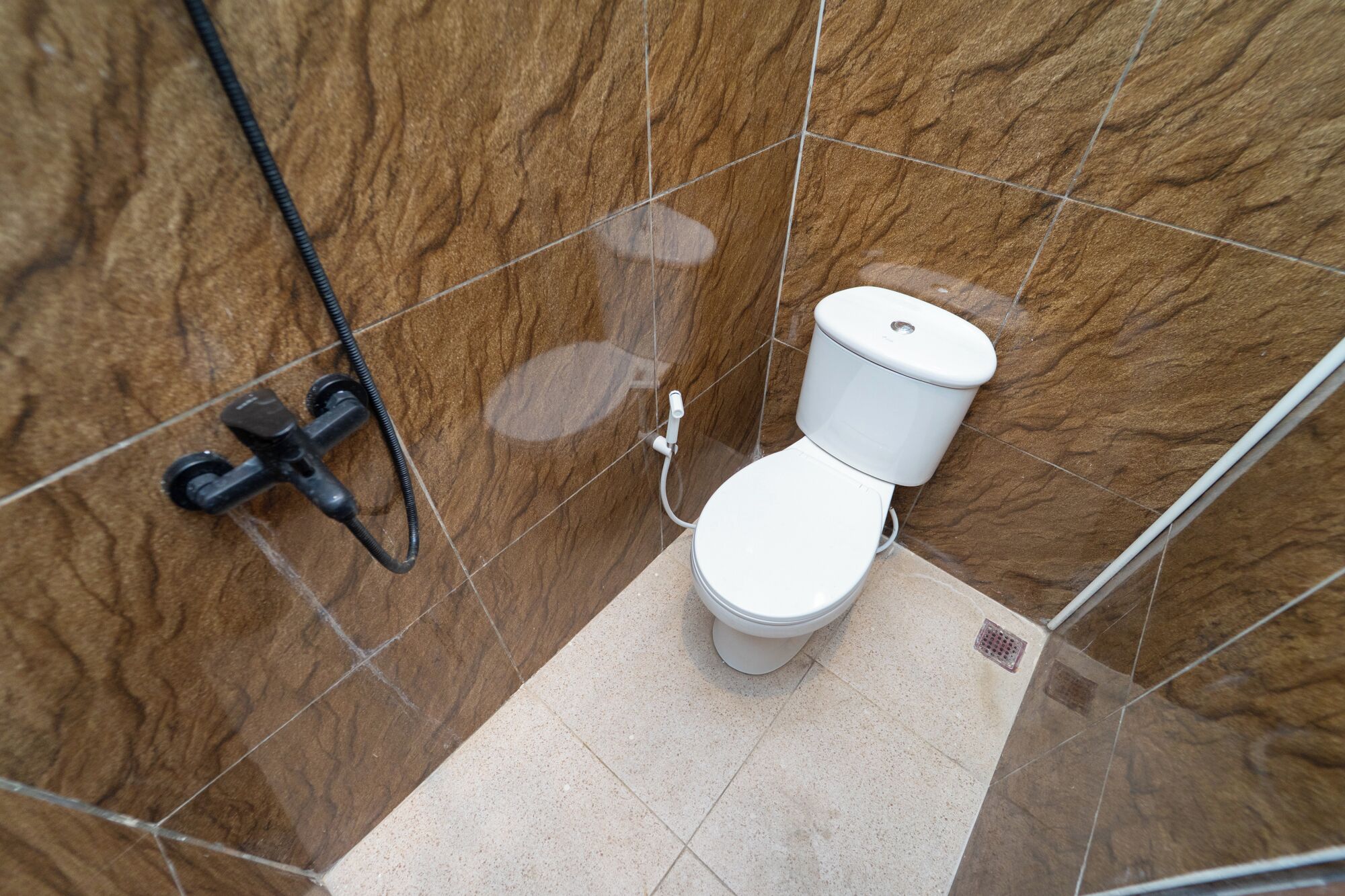 Un baño con inodoro, ducha y secamanos.