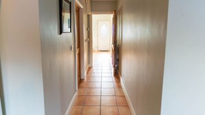 A hallway with a tiled floor, a door at the end, and a framed picture on the wall. - Riverview House Ireland Stay – Scenic Riverside Holiday Home in County Kerry (Cahersiveen)