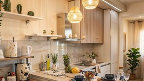 Una cuina moderna amb una illa central, tamboretes de bar, una màquina de cafè i diversos electrodomèstics.