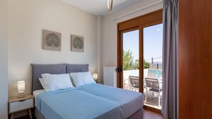 Una camera da letto con un letto, comodini, una finestra con tende e vista su uno spazio esterno.