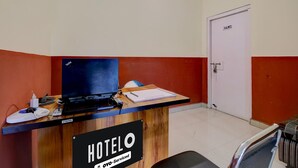 A hotel reception desk with a computer, a sign indicating it's serviced by OYO, and a door labeled 'HOTEL'. - Classic Guwahati Stay Inn (Guwahati)