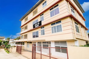 Un edificio de hotel de varios pisos con un cartel que indica que cuenta con servicios de Agoda.