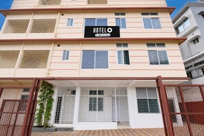 A multi-story hotel building with a sign reading 'HOTEL OYO Serviced'. - Classic Guwahati Stay Inn (Guwahati)