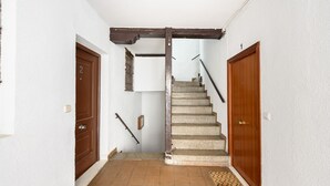 A staircase with a wooden handrail, a door with a number, and a tiled floor. - (MDP80314) 1 bedroom apartment in the center of Madrid (Madrid)