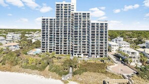 A high-rise hotel with multiple balconies, a pool area, and a beach view. - Seagrove Sunrise 1004-Beachfront Views-Sleeps 6 (Seagrove Beach)