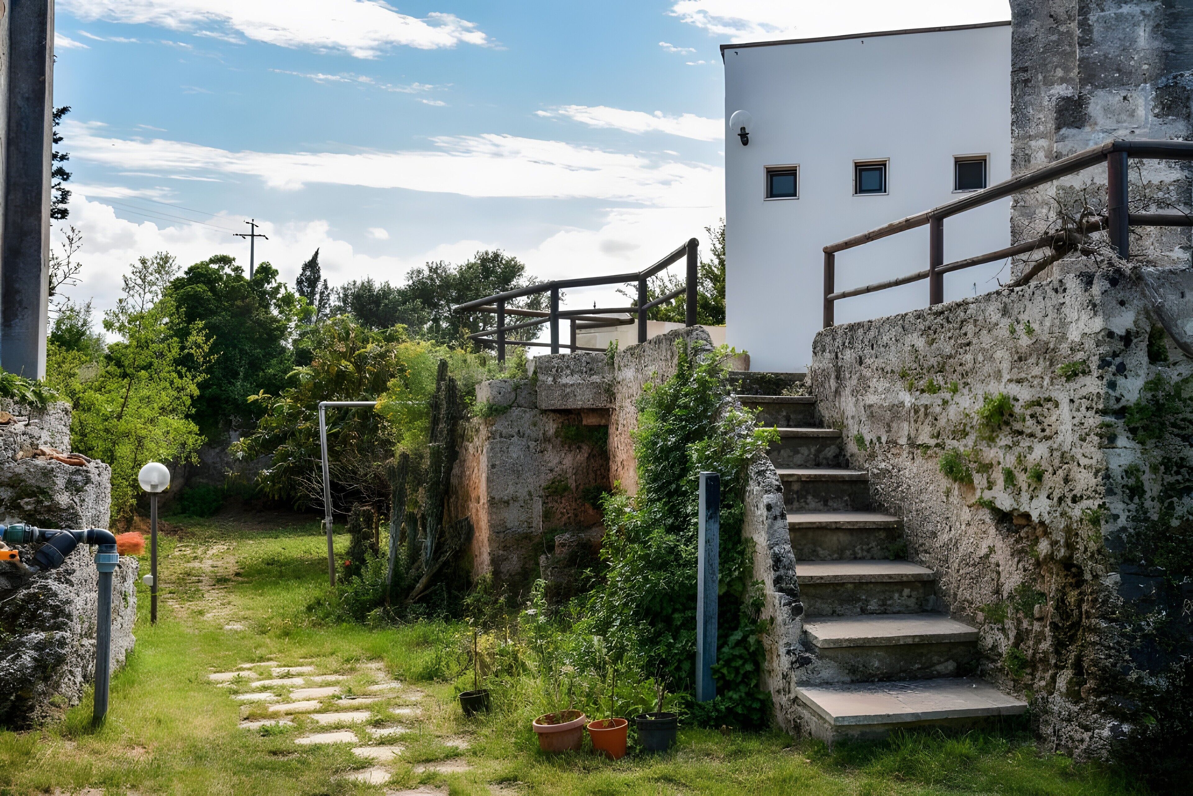 A pathway leading to a white building with a staircase.