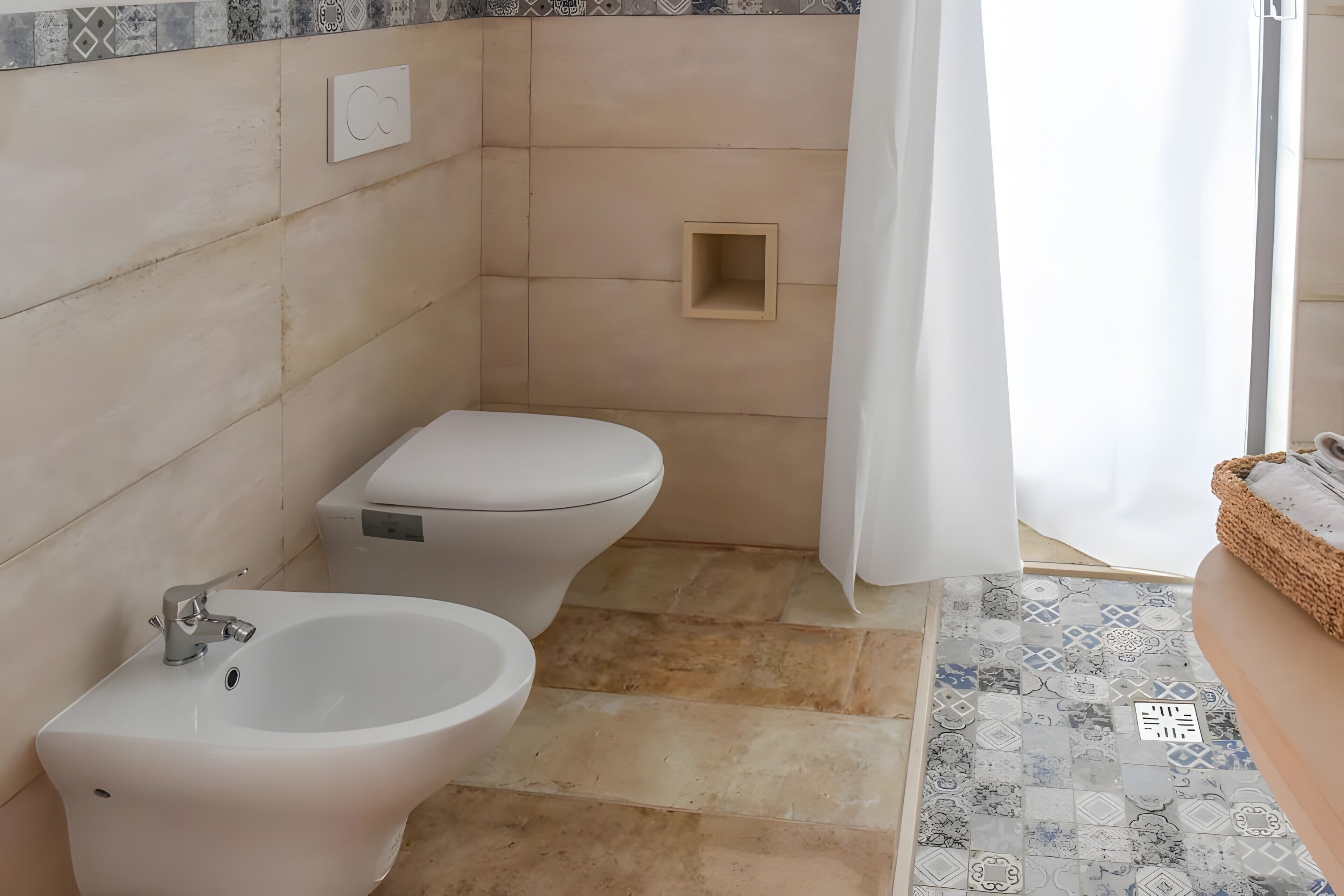 A bathroom with a bidet, toilet, and a shower area.