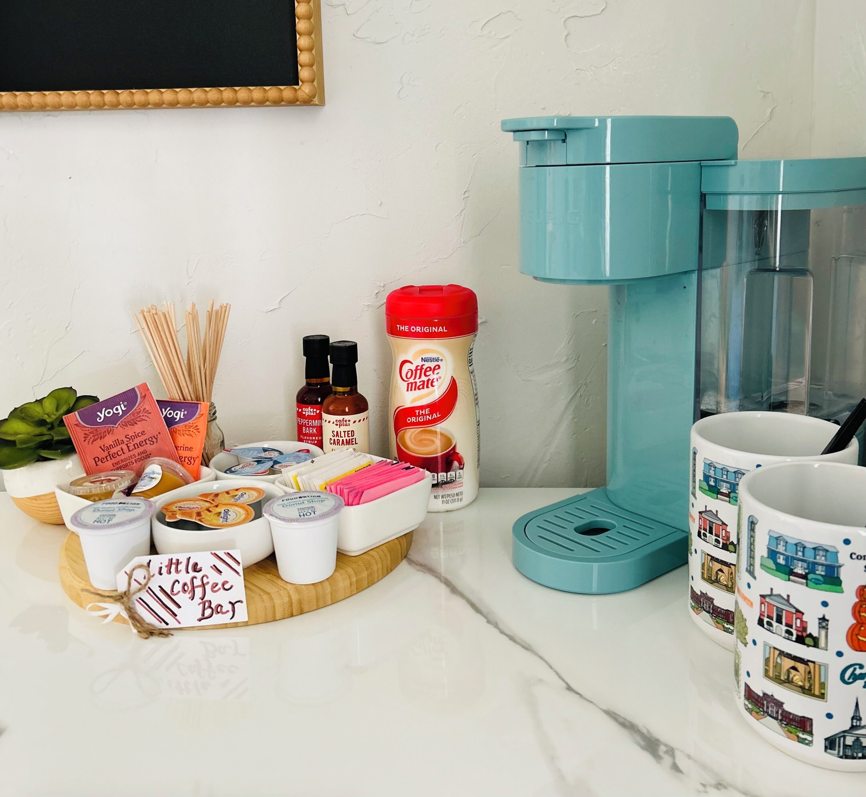 Een koffiehoek met een koffiezetapparaat, mokken en diverse koffieaccessoires.