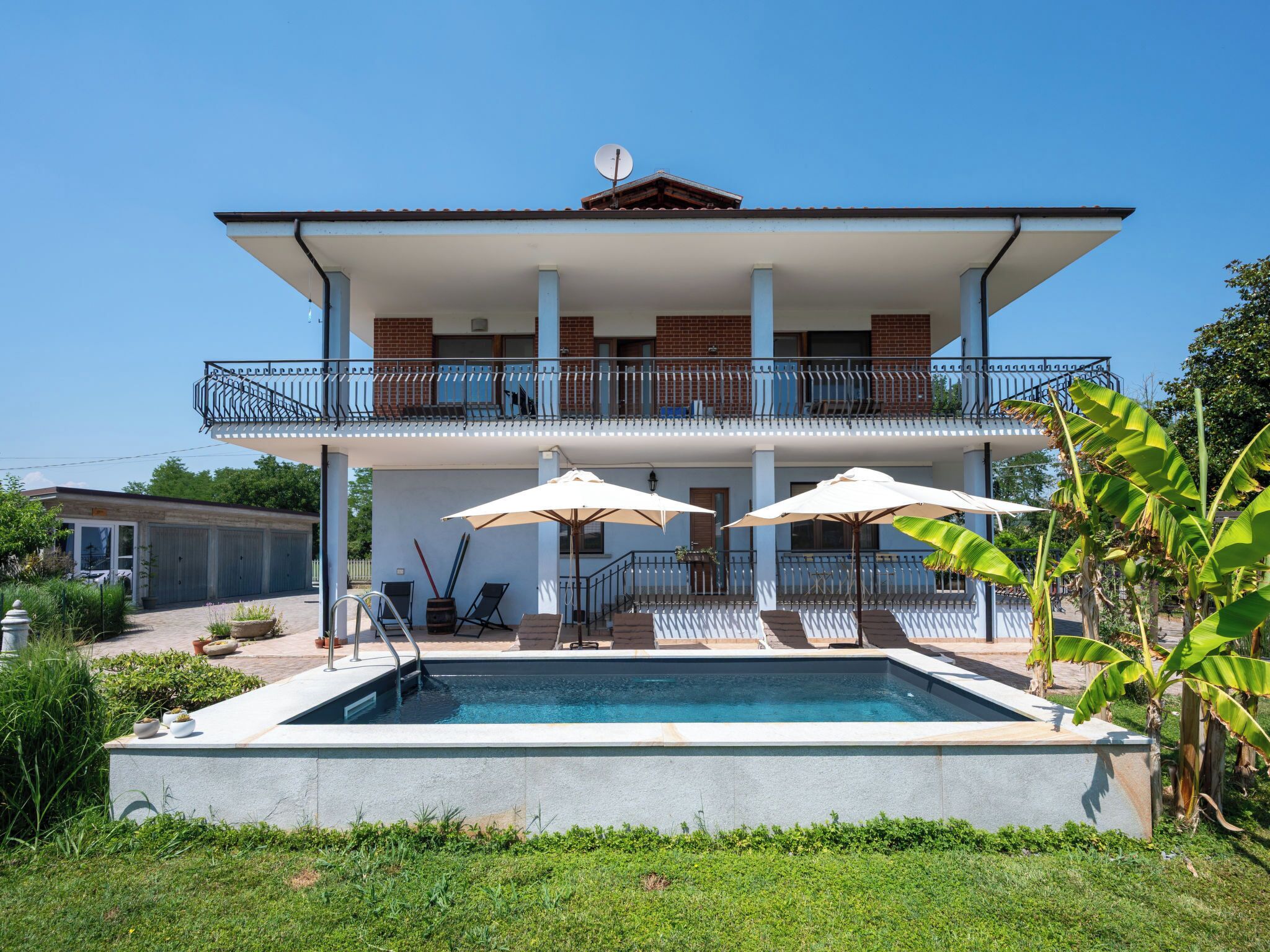 Un bâtiment à deux étages doté d’une piscine, d’un espace extérieur aménagé et d’un balcon.