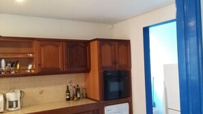A kitchen with wooden cabinets, a built-in oven, and a dishwasher. - A beautiful apartment surrounded by nature behind Grande Anse Beach, Deshaies (Deshaies)