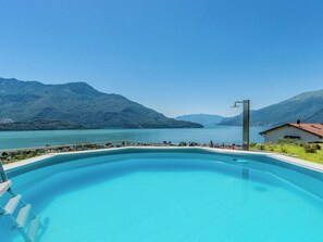 Piscina com vista para um lago e montanhas.
