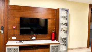 Un mueble de madera con un televisor de pantalla plana, un extintor y un panel decorativo.