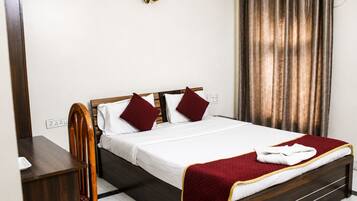 A neatly made bed with a white and red bedspread, a wooden headboard, and two red pillows.