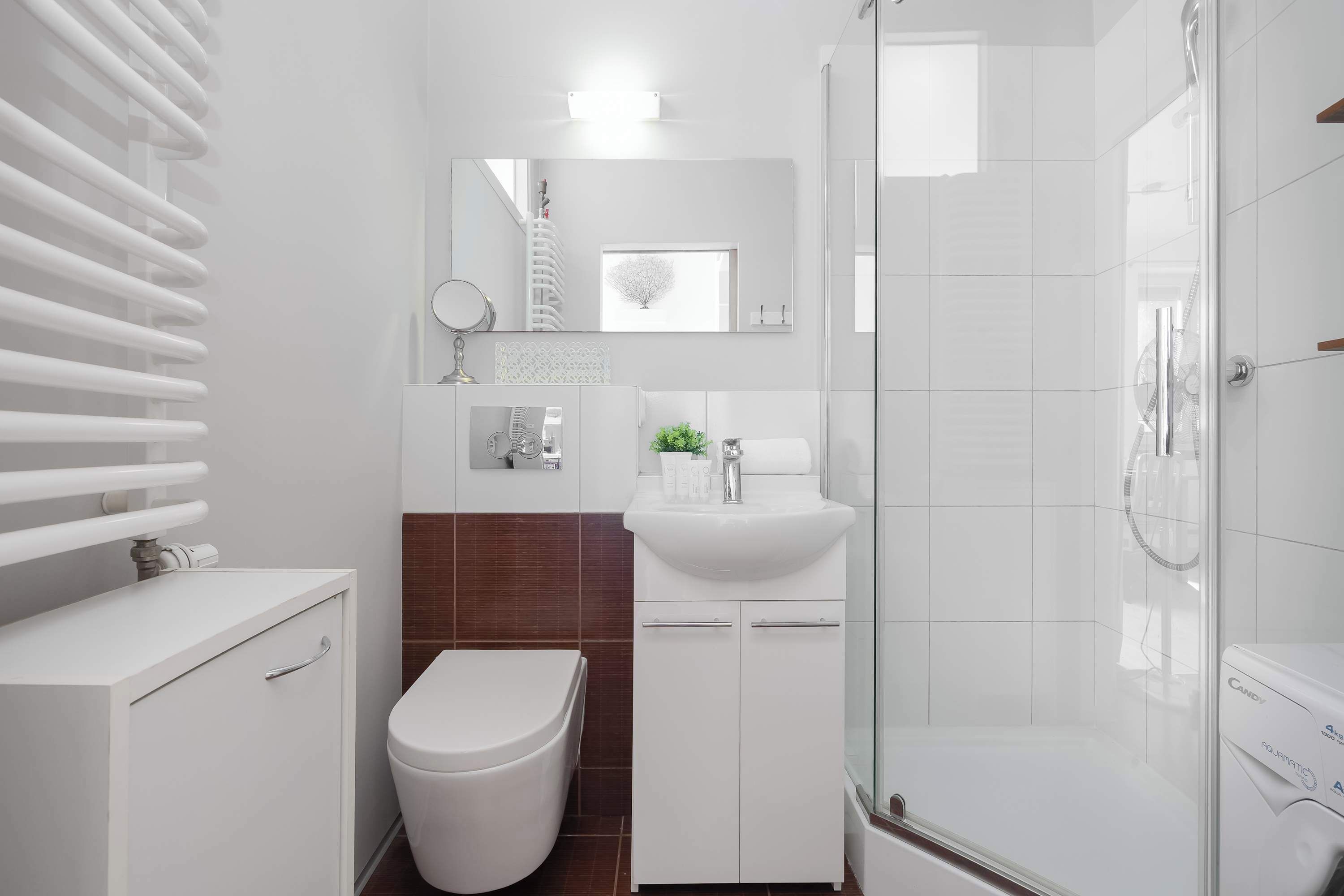 Une salle de bain moderne équipée de toilettes, d’un lavabo et d’une douche.