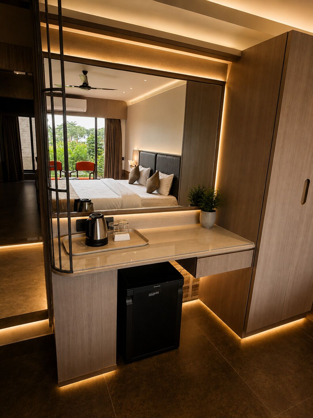 Una habitación de hotel moderna con una cama, una mesita de noche y una pequeña zona de kitchenette.