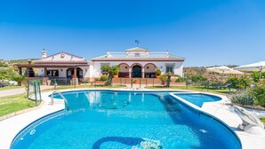 Una piscina grande con una casa al fondo.