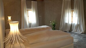 Een kamer met een bed, een lamp en gordijnen.