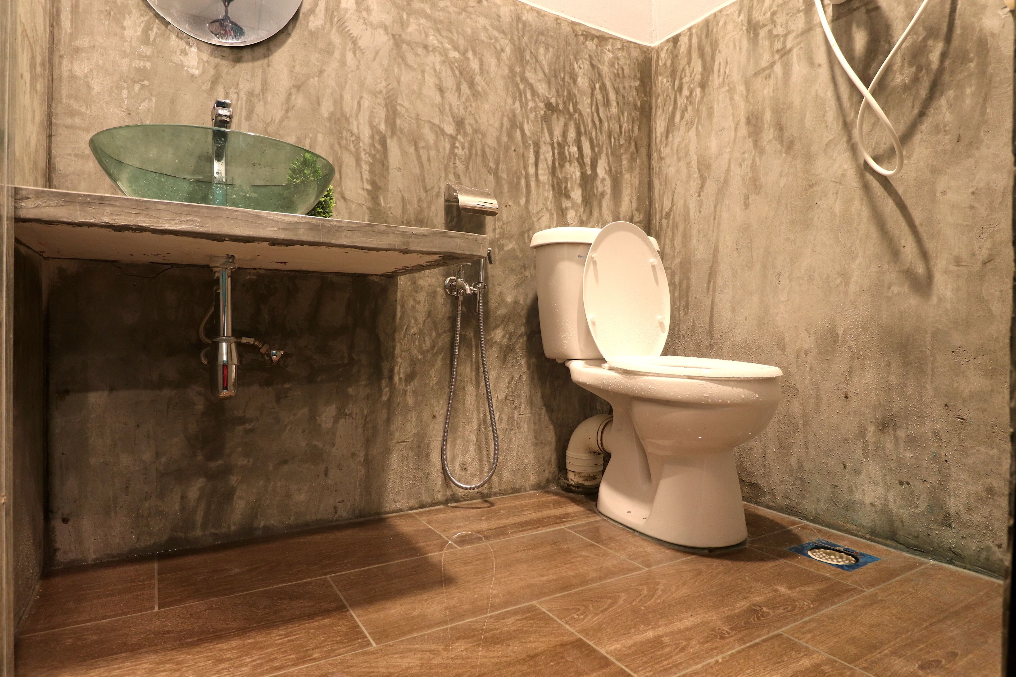 Un baño con un lavabo de cristal, inodoro y ducha.