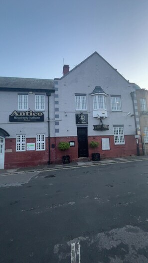 Um edifício de dois andares com uma placa indicando 'Antico Ristorante Italiano' no andar térreo.